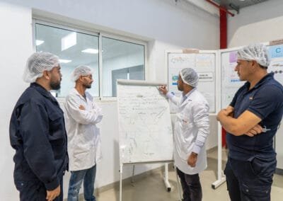 AXOPLAST team briefing around a production whiteboard